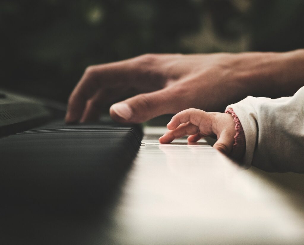 Parent and child playing piano